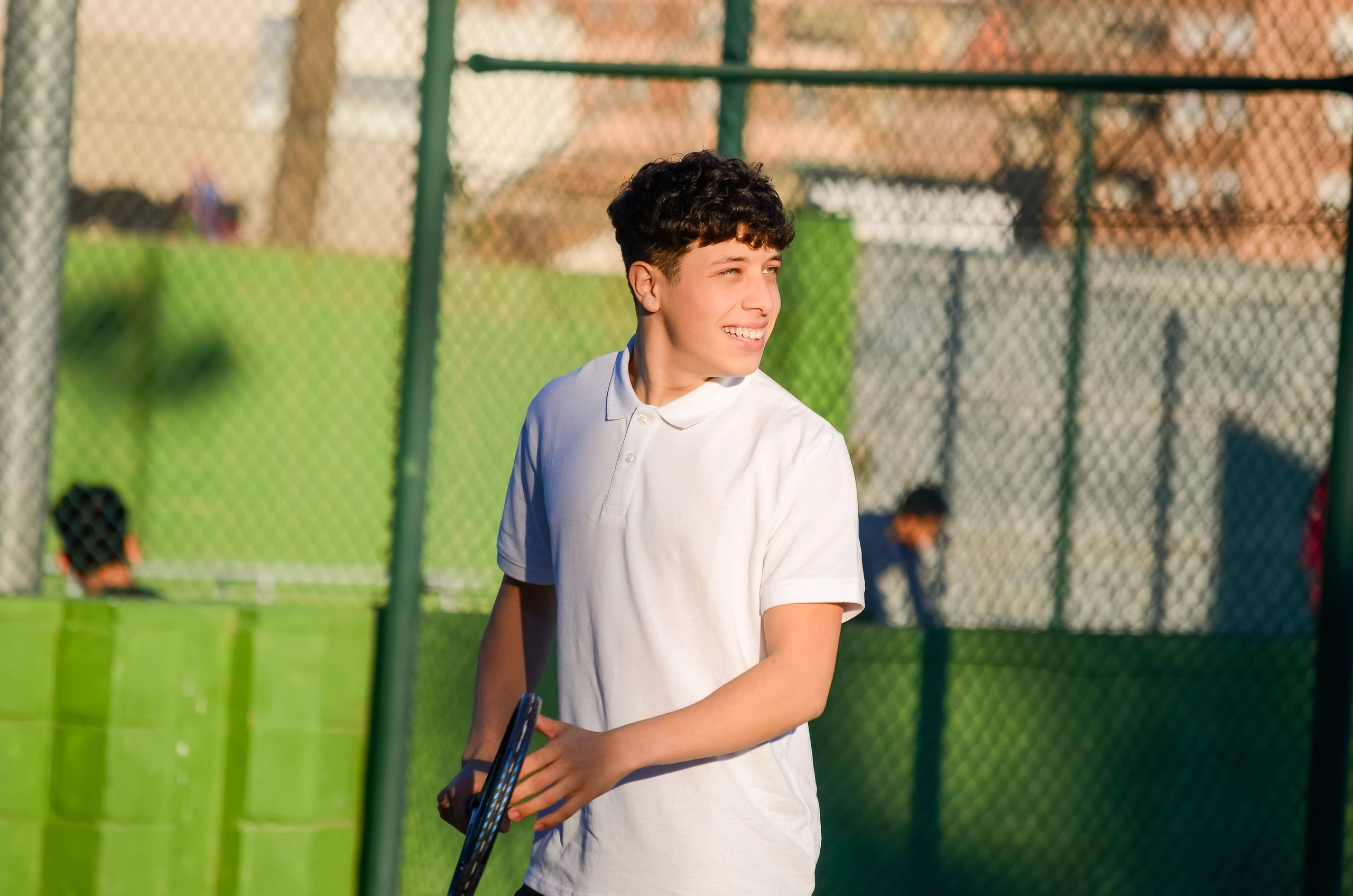 Teen tennis player holding a racket on court