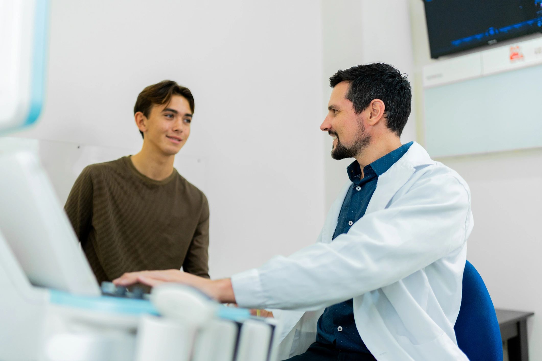 Teen athlete speaking with a doctor during an exam